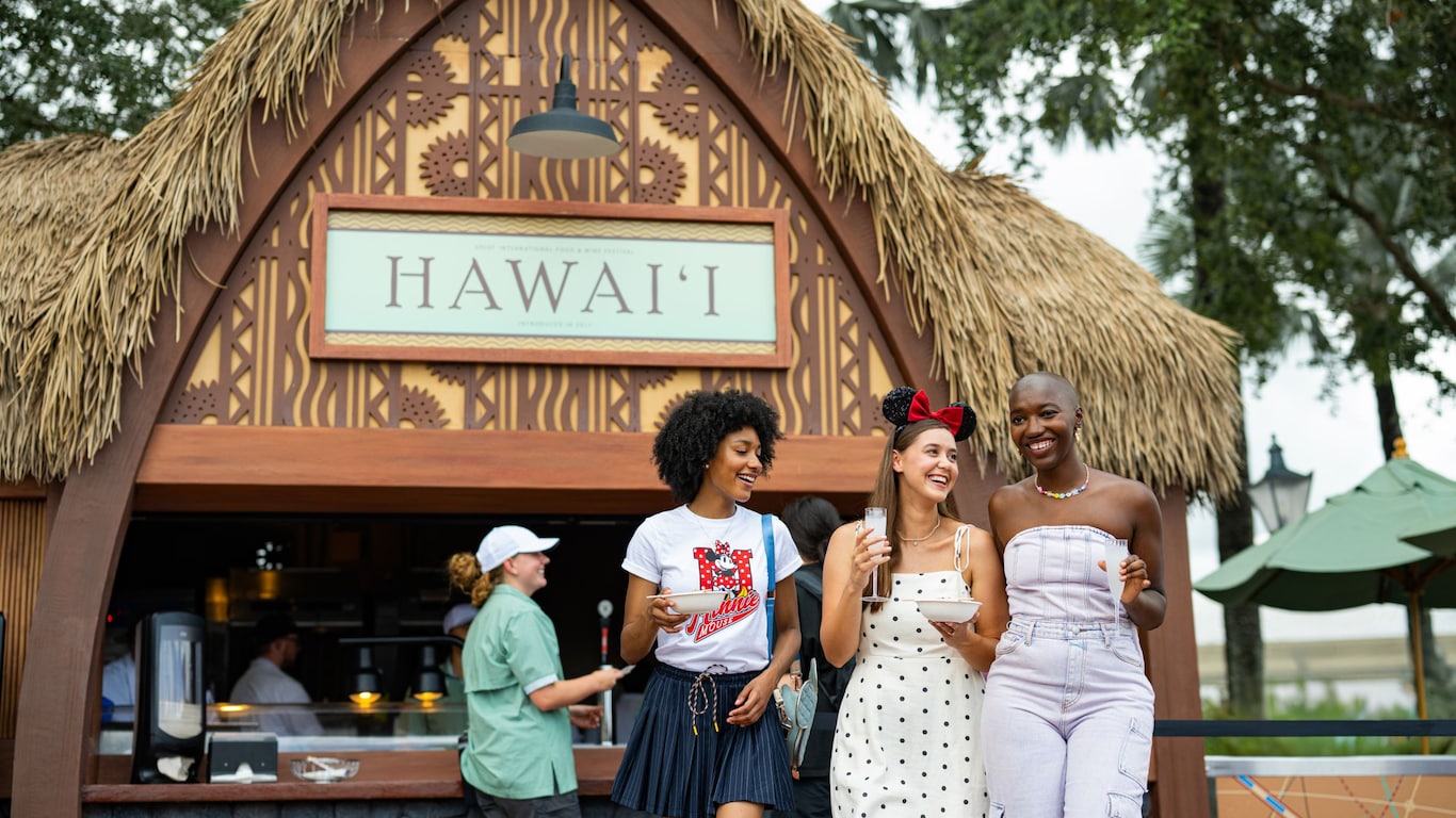 Three Guests enjoying food and drinks at the Hawaii booth during the Epcot International Food & Wine Festival