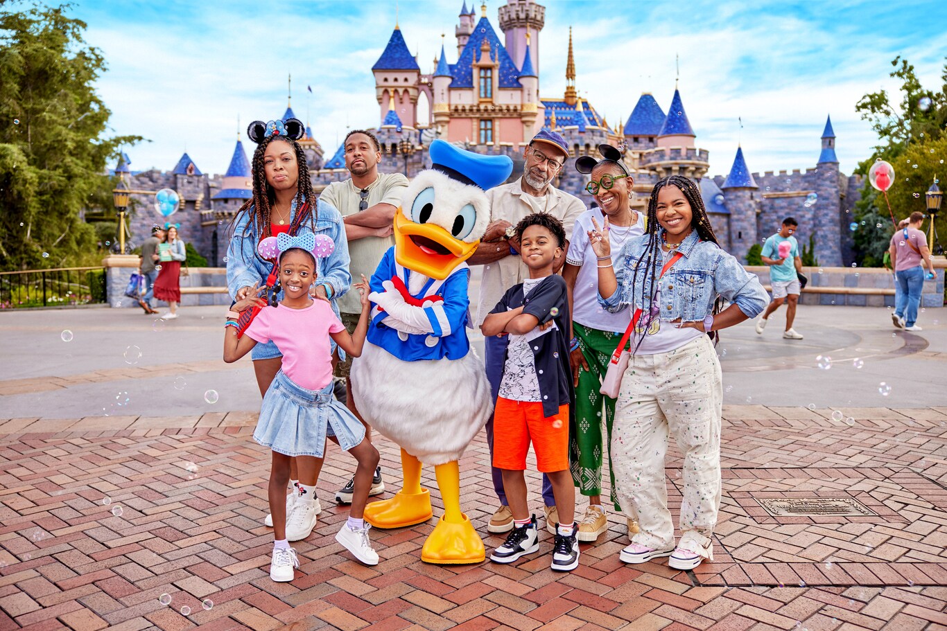 A family standing with Donald Duck and posing
