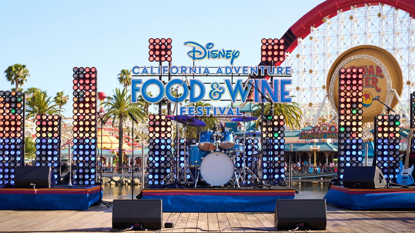 A stage with musical instruments and the words 'Disney California Adventure Food & Wine Festival,' with Pixar Pal A Round in the background