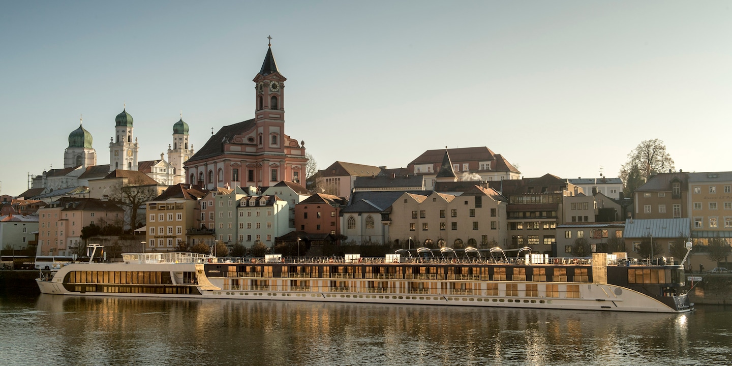 An AmaWaterways ship cruises along the Danube River past the town of Passau, Germany