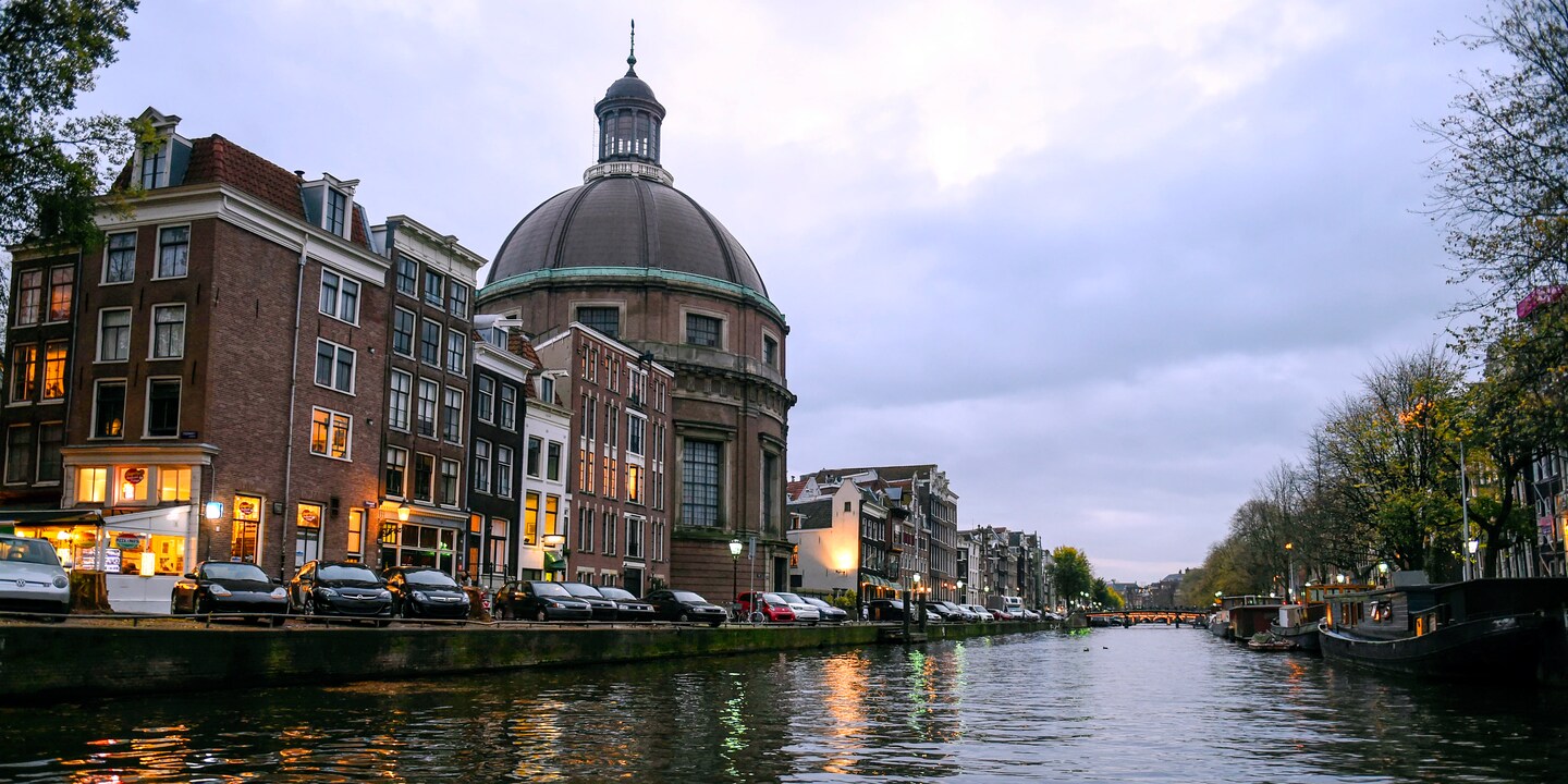 A picturesque view of Amsterdam, with a domed building, taken from the Rhine River
