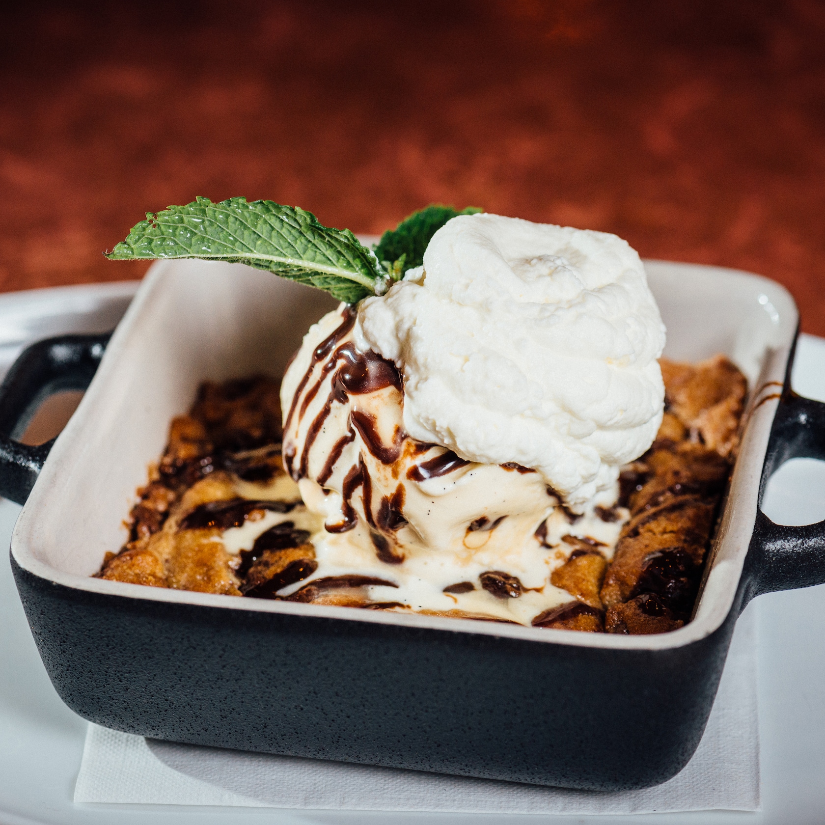 With sweet selections like the Baked Cookie Dough and S’mores Dip, you’re definitely going to want to save room for dessert. slide 60 of 12 Baked Cookie Dough dessert topped with cream and a sprig of mint