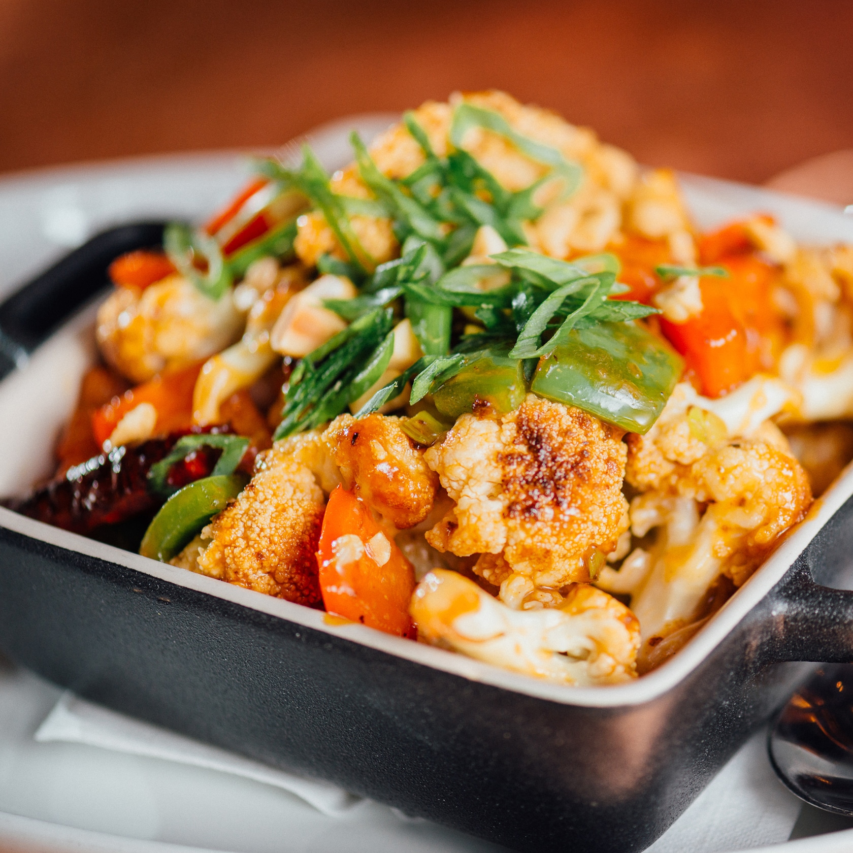 Discover gluten-free options galore, including our Kung Pao Cauliflower starter. slide 54 of 12 Kung Pao Cauliflower in a casserole style serving dish next to a spoon