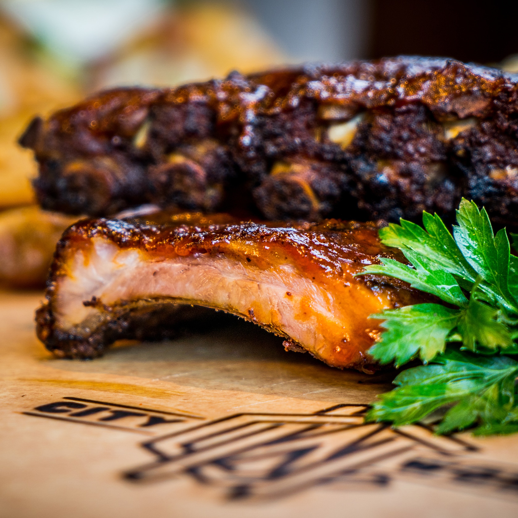 Nothing says gameday like a helping of Smoked Barbecue Ribs—our dish boasts a house made BBQ sauce, spicy maple bacon baked beans and mascarpone creamed corn. slide 51 of 12 Smoked Barbecue Ribs with a garnish