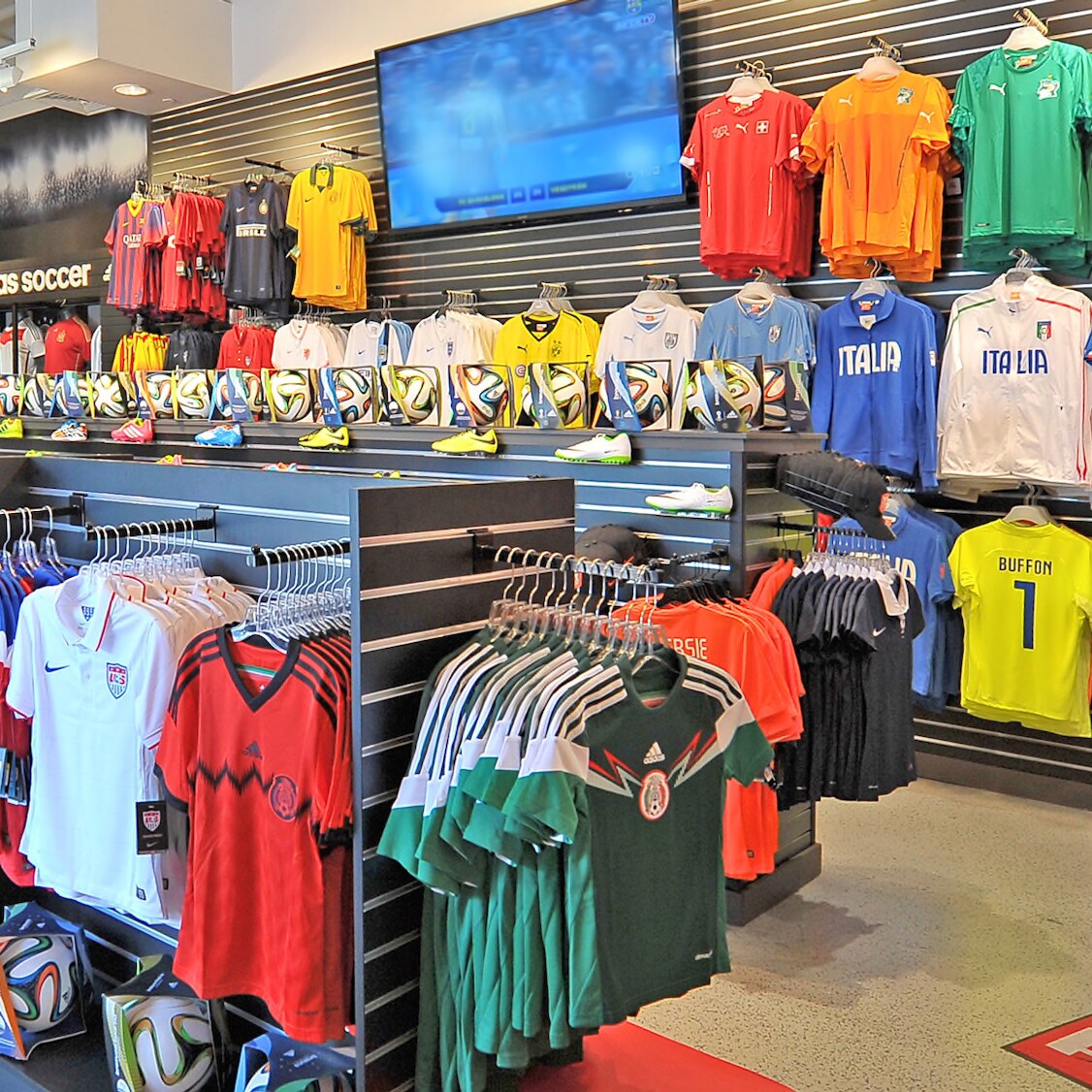 Soccer jerseys hanging on display islands and on walls inside an apparel store