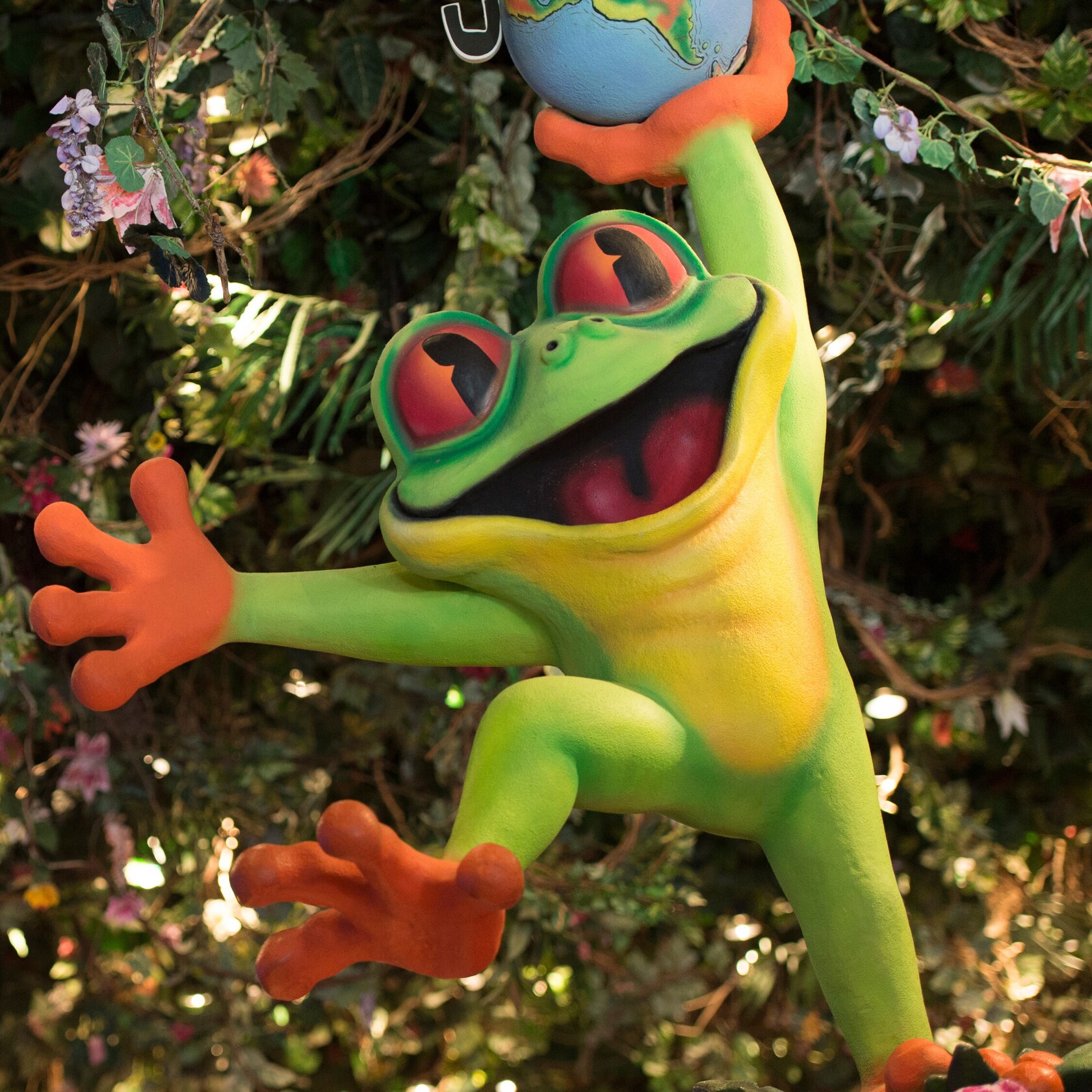 A large, smiling tree frog display welcomes Guests to the Rainforest Café