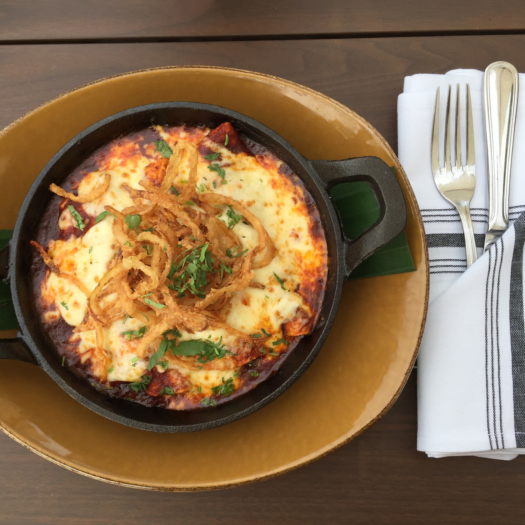 Indulge your appetite with irresistible Mexican fare like the Red Chile Chicken Enchiladas, made with fresh-made tortillas, queso Chihuahua, black beans and crispy onions. slide 80 of 16 Enchiladas served in a cast iron dish and topped with melted cheese, crispy onion and cilantro
