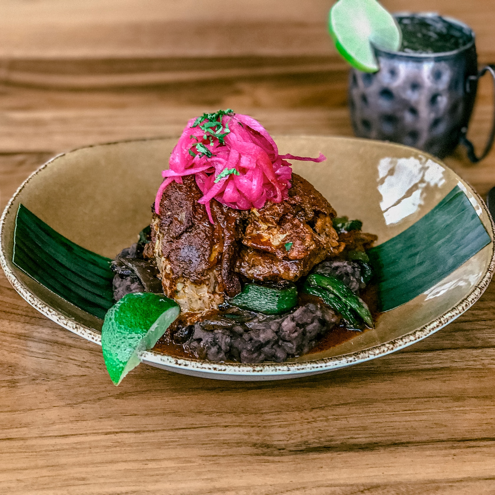 Make your meal a fiesta with slow-roasted carnitas served with refried black beans, queso fresco, guacamole, pickled red onions, salsa verde and warm tortillas. slide 78 of 16 Slow roasted pork served with black beans and topped with pickled onions