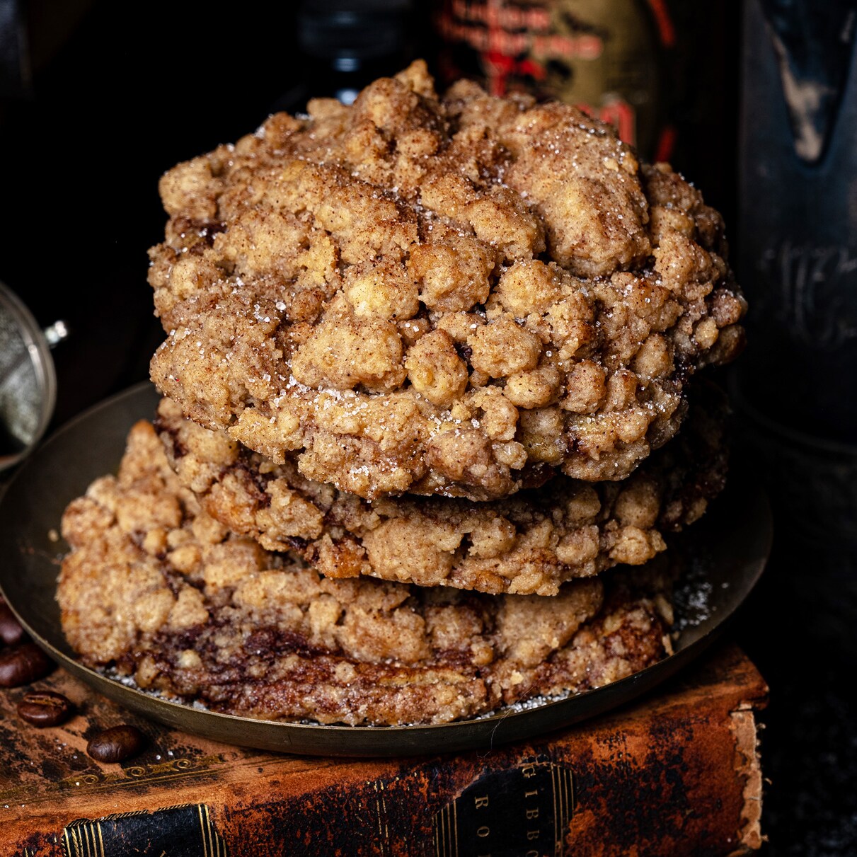 A stock of Coffee Cake Cookies sitting on an old book surrounded by coffee beans