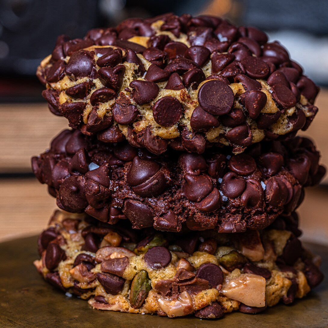 Chocolate Chip, Triple Chocolate, and Pistachio Toffee Cookies stacked on top of each other