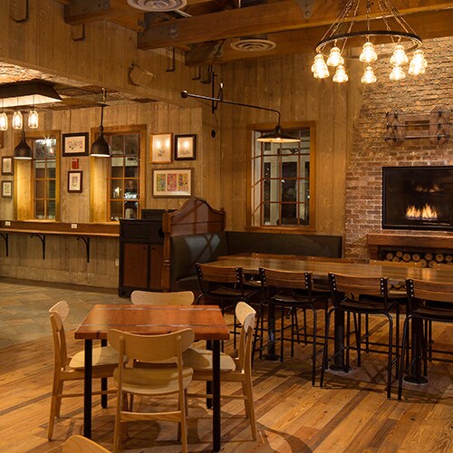 Decoración ecléctica, iluminación rústica, y toques de ladrillo y madera adornan el comedor de D-Luxe Burger