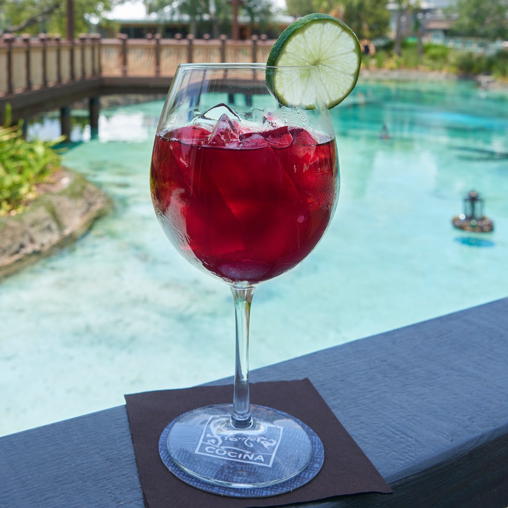 Score an outdoor table and enjoy the sights and sounds of Disney Springs as you sip on a glass of flavorful sangria. slide 79 of 16 Jamaica sangria on a logo glass with a lime garnish