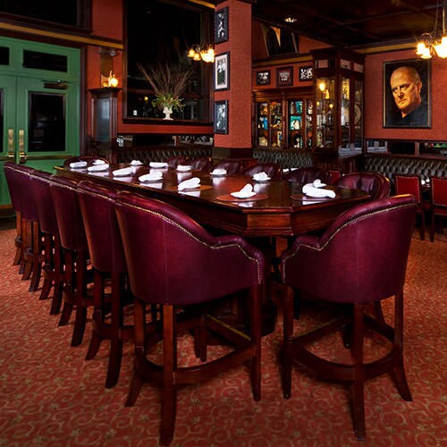 Mahogany leather-upholstered chairs and a long table in an alternate dining room