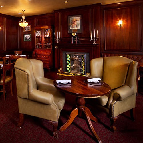 Two oversized leather armchairs and a small table in a lounge area