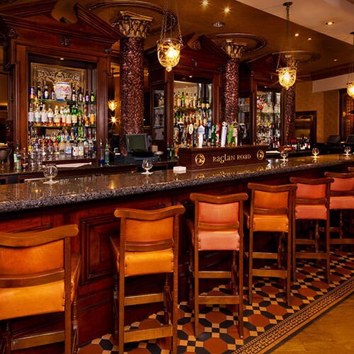 A row of bar chairs at a long granite-topped bar