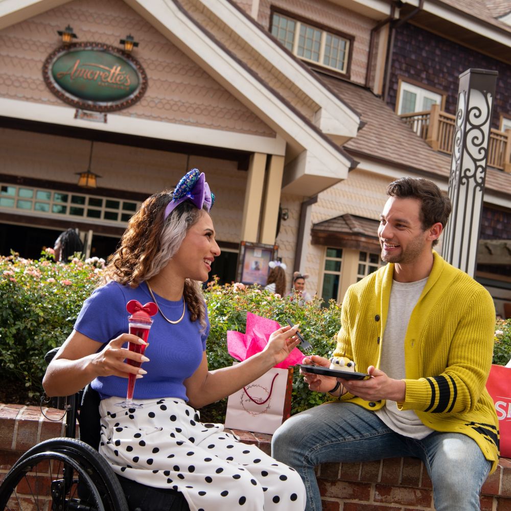 Pair a dazzling dessert with sparkling wine at this charming patisserie. slide 17 of 4 A young couple enjoys cake and sparkling wine outside Amorette’s Patisserie at Disney Springs
