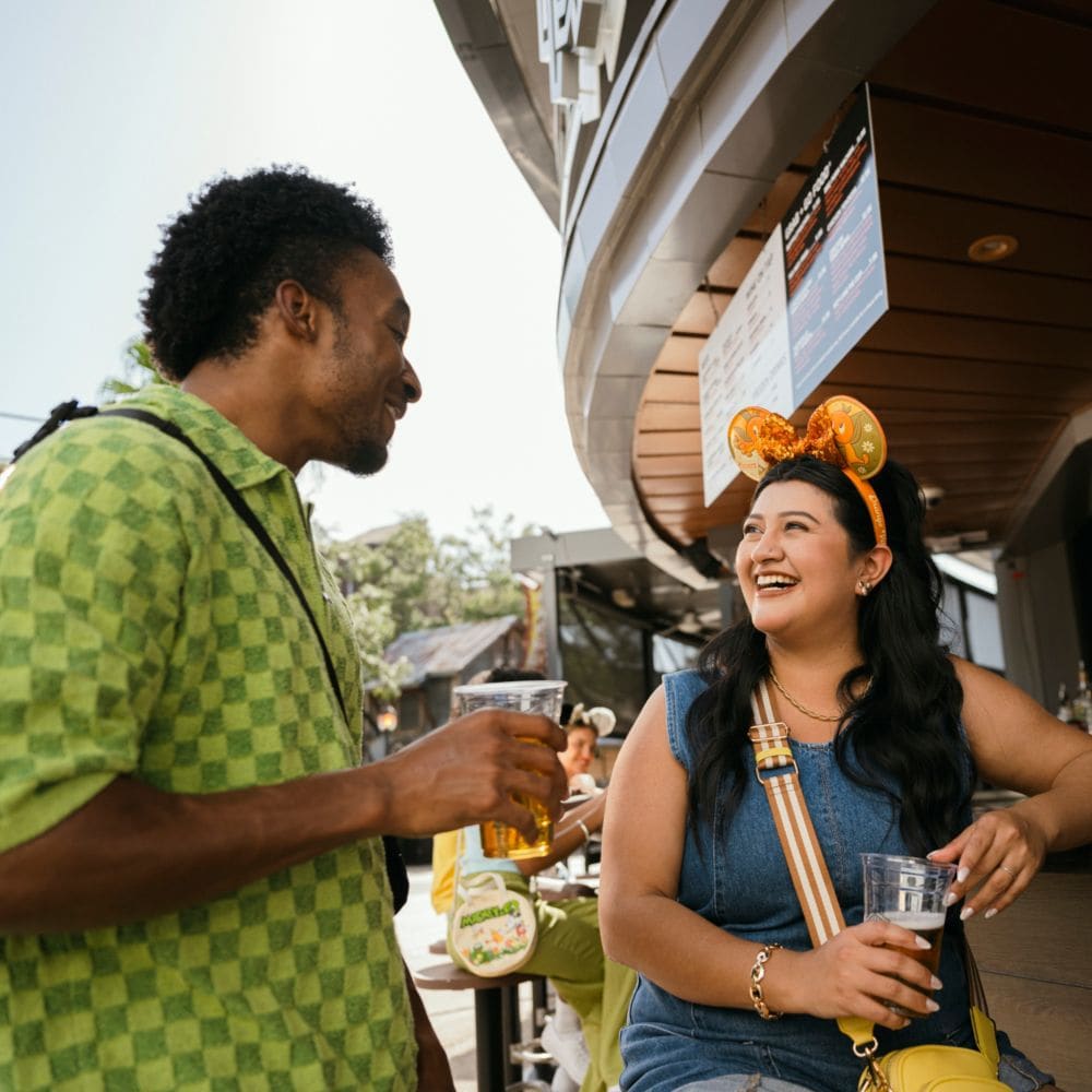 Great drinks and even better company-make your next night out one to remember at City Works Eatery & Pour House! slide 49 of 12 A man and a woman chatting while drinking adult beverages at an outdoor bar at City Works Eatery & Pour House