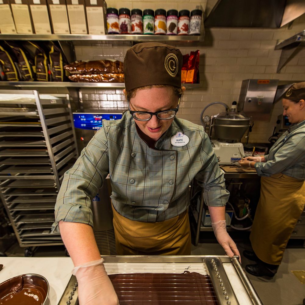 Watch as expert chocolatiers handcraft delicious treats in the showcase kitchen. slide 23 of 5 Two chocolatiers making ganache treats in the kitchen at The Ganachery