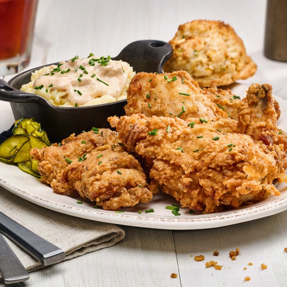 Bite into classic country favorites like crispy fried chicken. slide 29 of 7 A fried chicken dinner platter with mashed potatoes and a biscuit