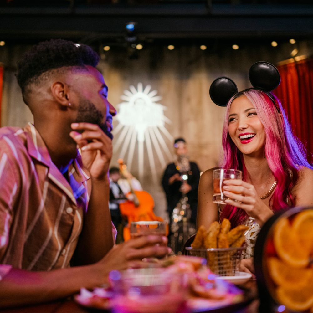 Guests enjoying beverages at a dining table full of dishes at The Edison