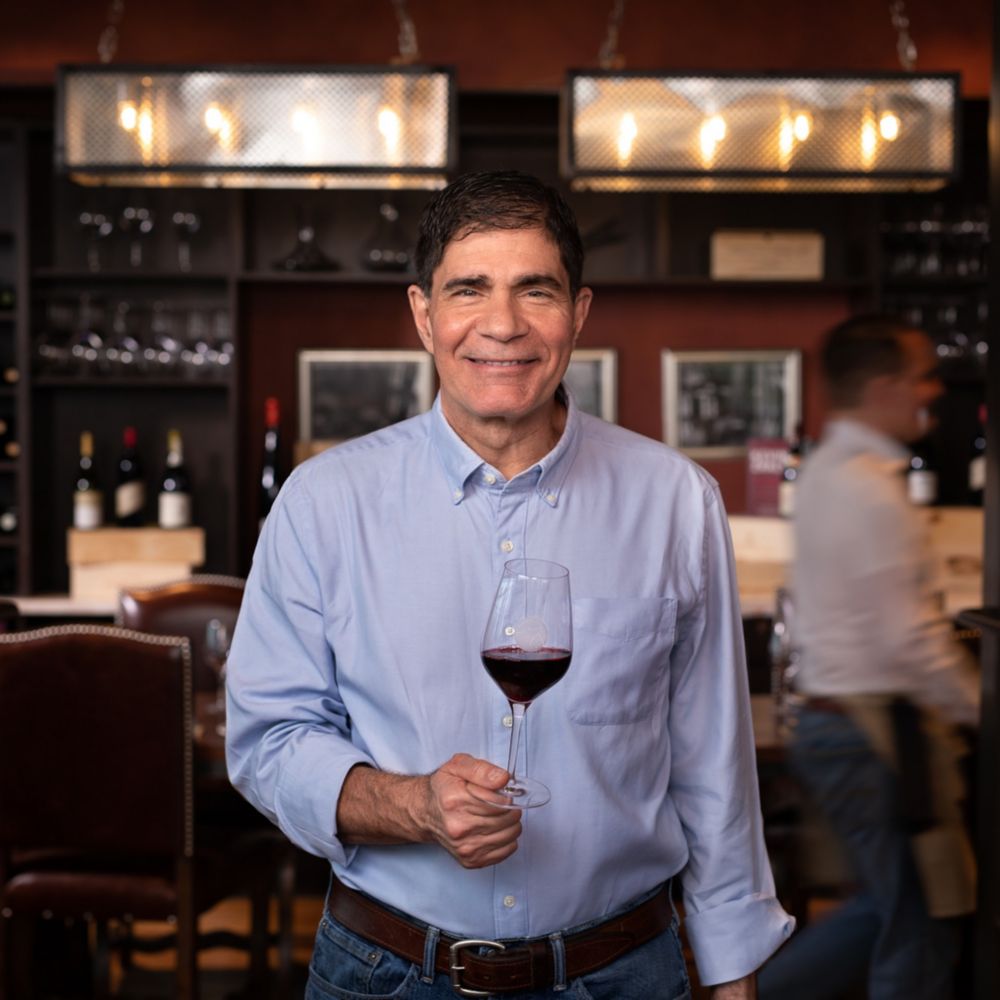 Master Sommelier George Miliotes holding a glass of wine