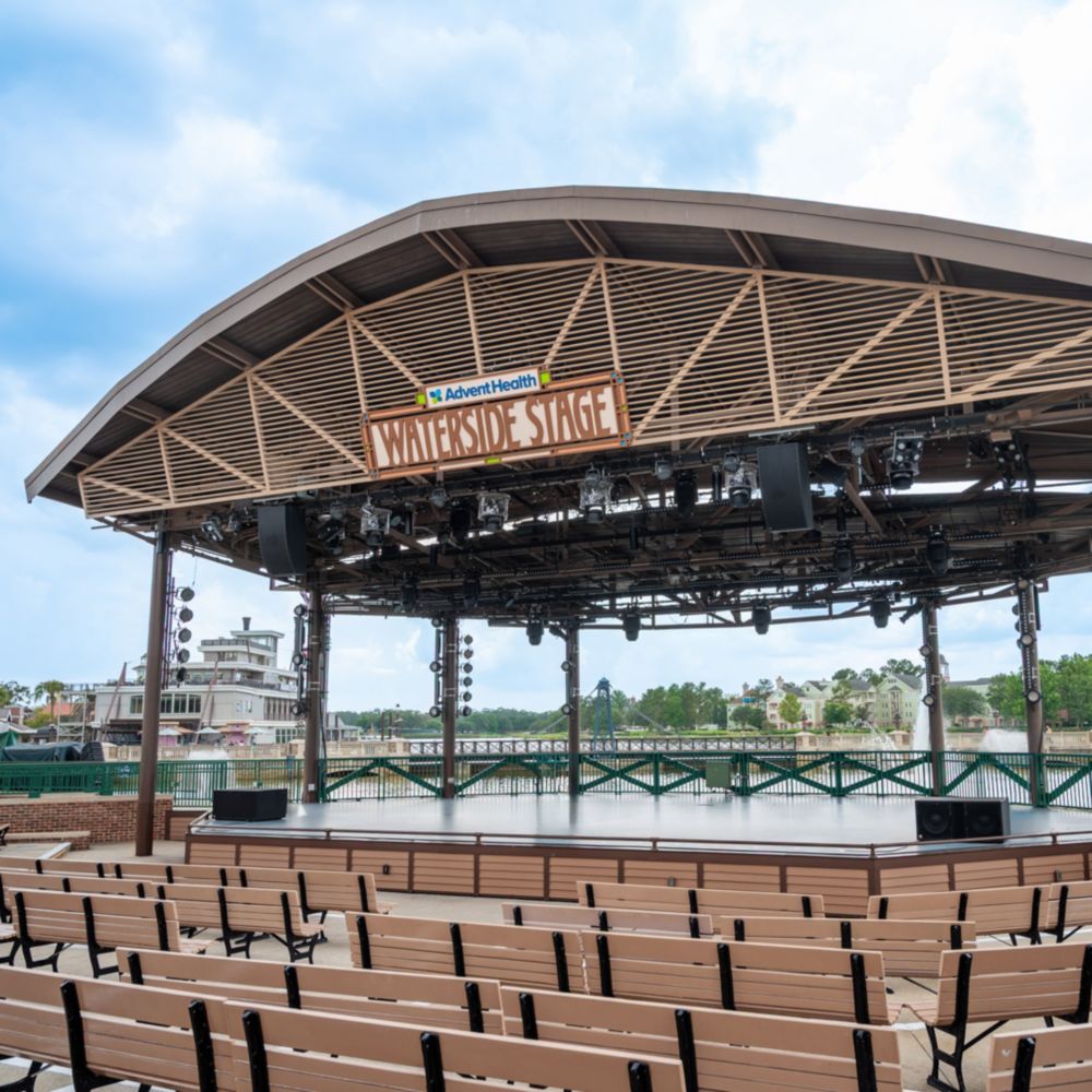The AdventHealth Waterside Stage at Disney Springs with rows of empty benches