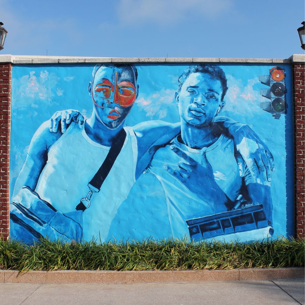 A mural along a pathway featuring 2 boys arm in arm