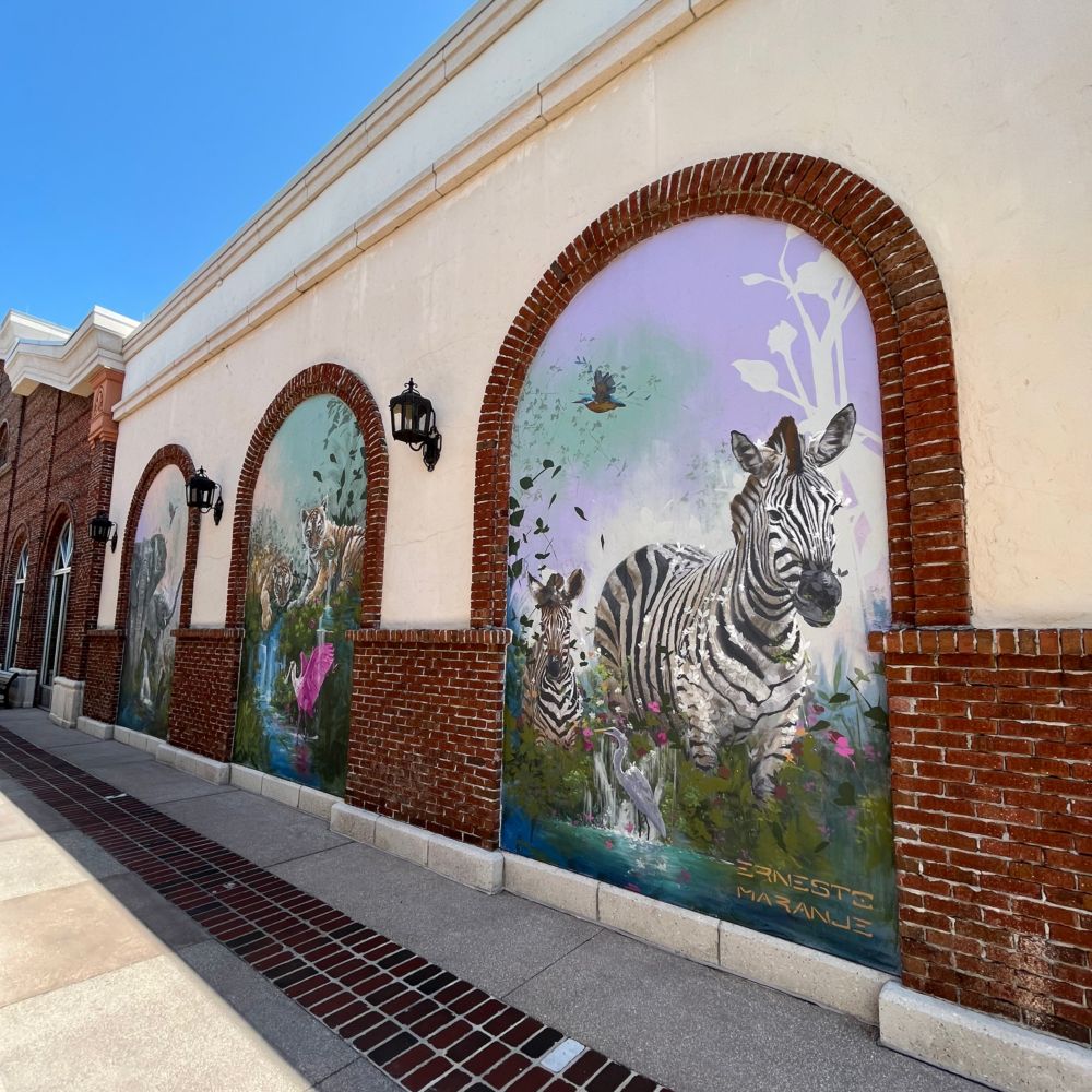 A triptych on a wall at Disney Springs filled with elephants, tigers and zebras