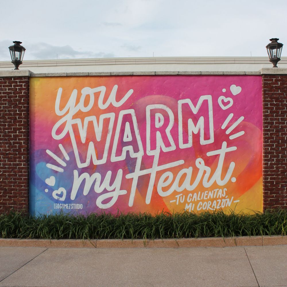 A mural on a brick wall featuring the words, ‘You Warm My Heart’