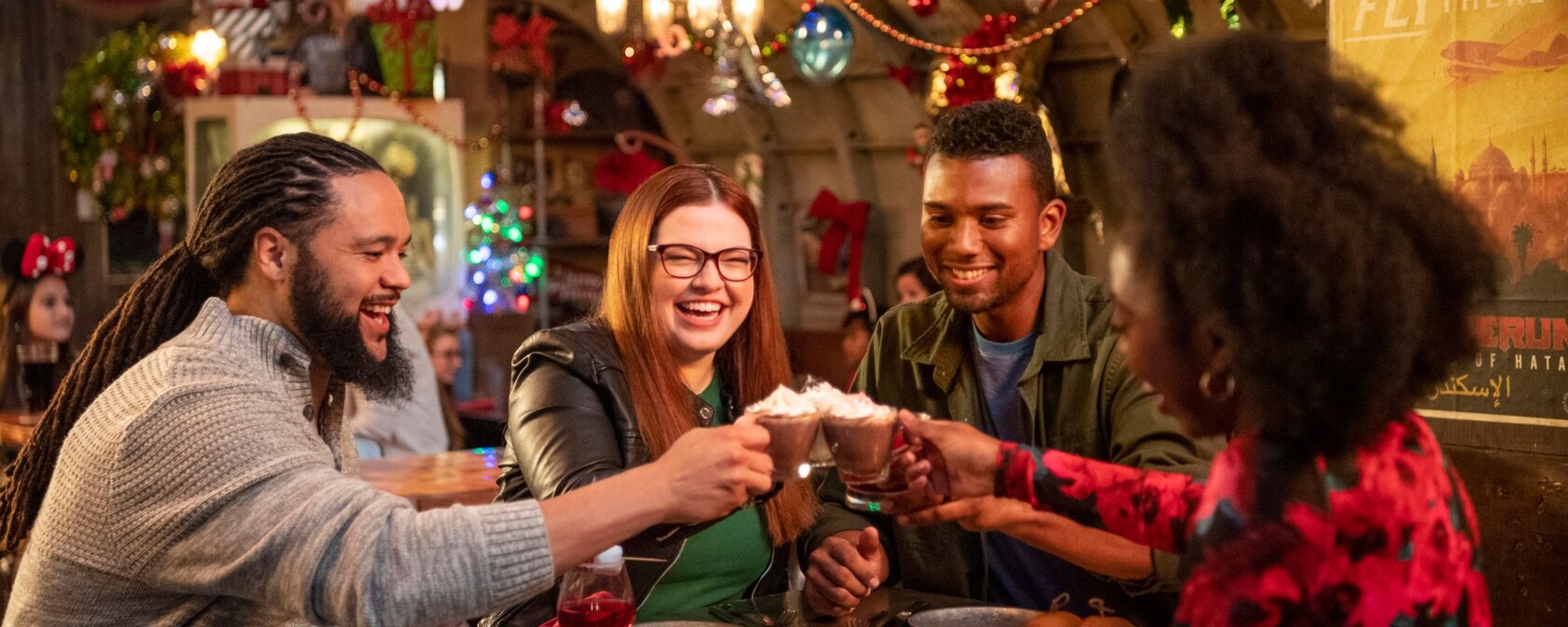 A group of friends toast while sitting at a table