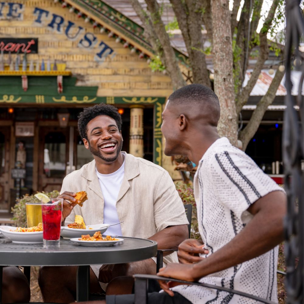 Three men dining outside at a table on the patio near House of Blues Restaurant & Bar