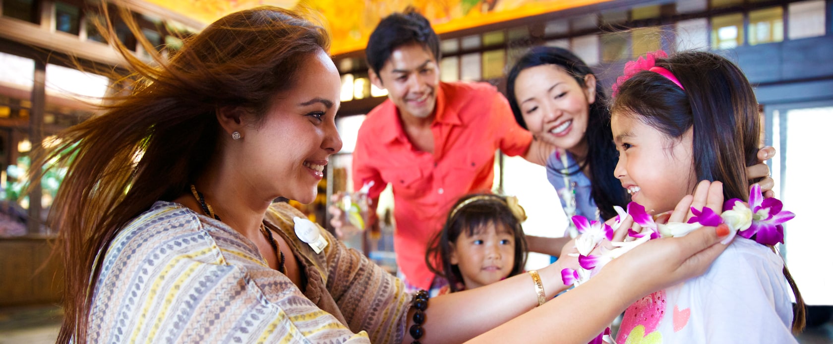 A family receives leis in the Lobby at Aulani Resort