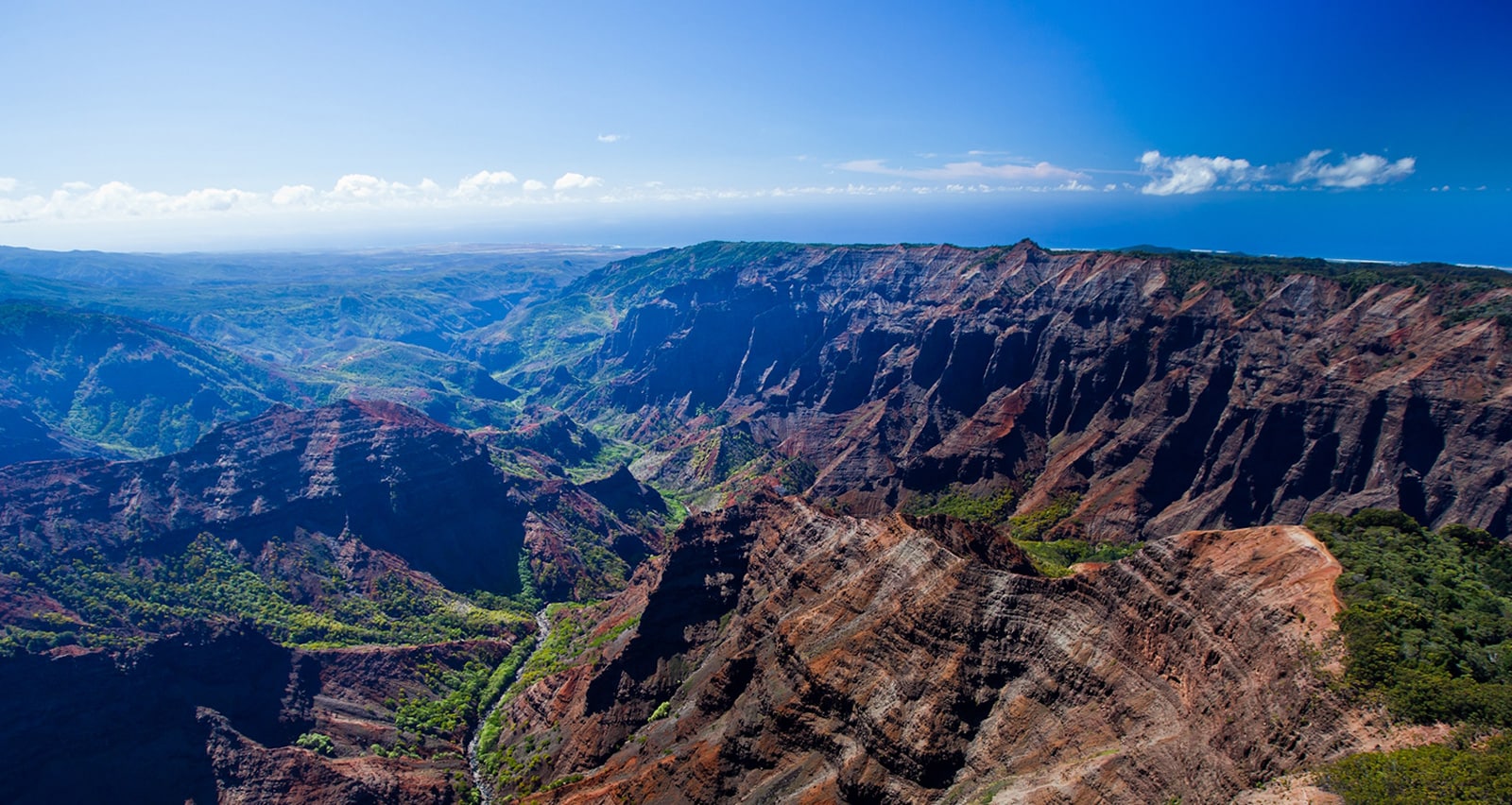 A sweeping panoramic view of rugged canyons and lush green valleys