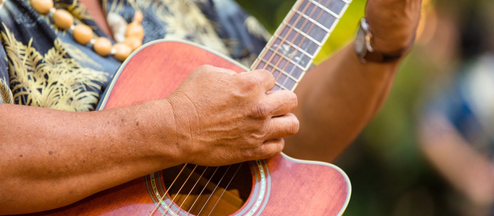 A hand gently strums a guitar
