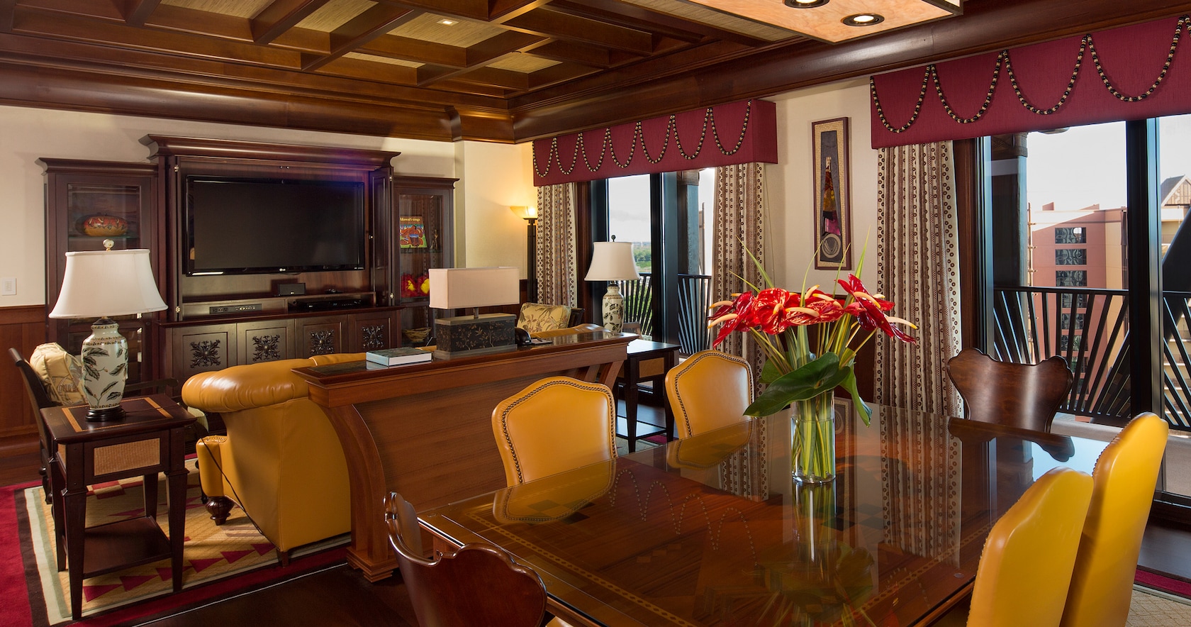 The living area of the 2-Bedroom Suite includes an entertainment center, seating area and dining table