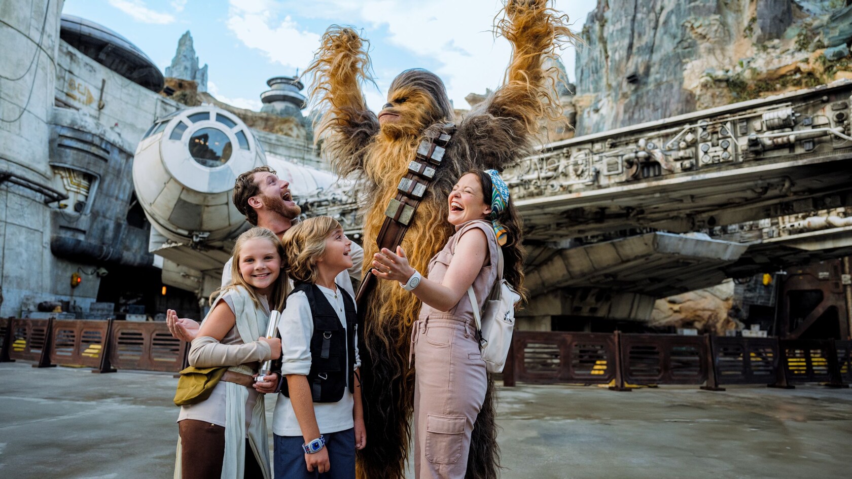 Una familia de cuatro integrantes posa para una foto con Chewbacca en Star Wars Galaxy’s Edge en Disney’s Hollywood Studios