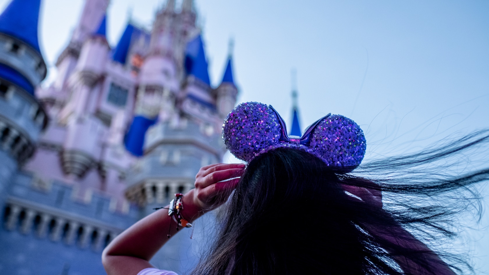 Girl wearing purple Mickey Ears in front of the Cinderella Castle