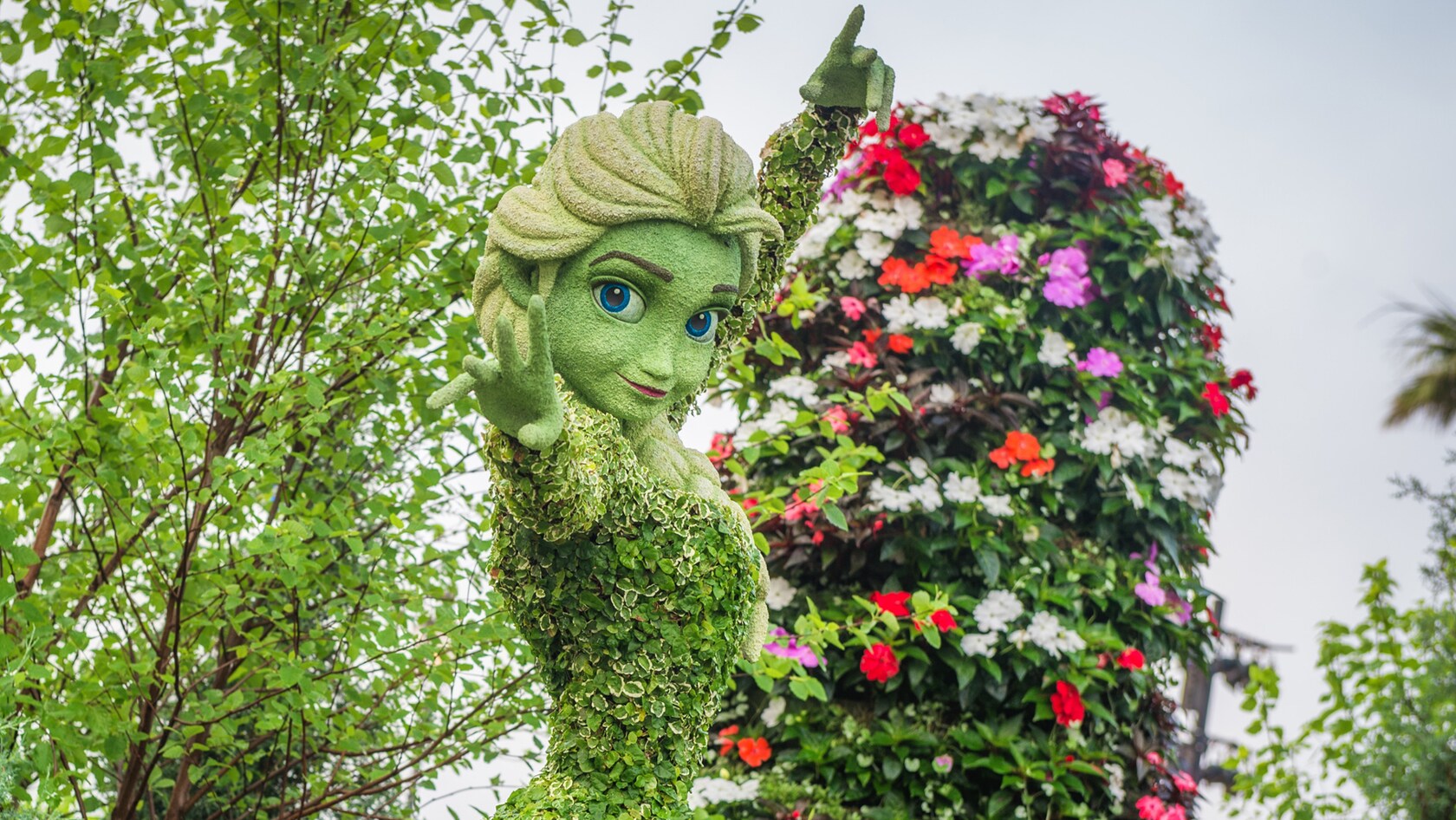 A topiary of Elsa smiling and doing a magical gesture