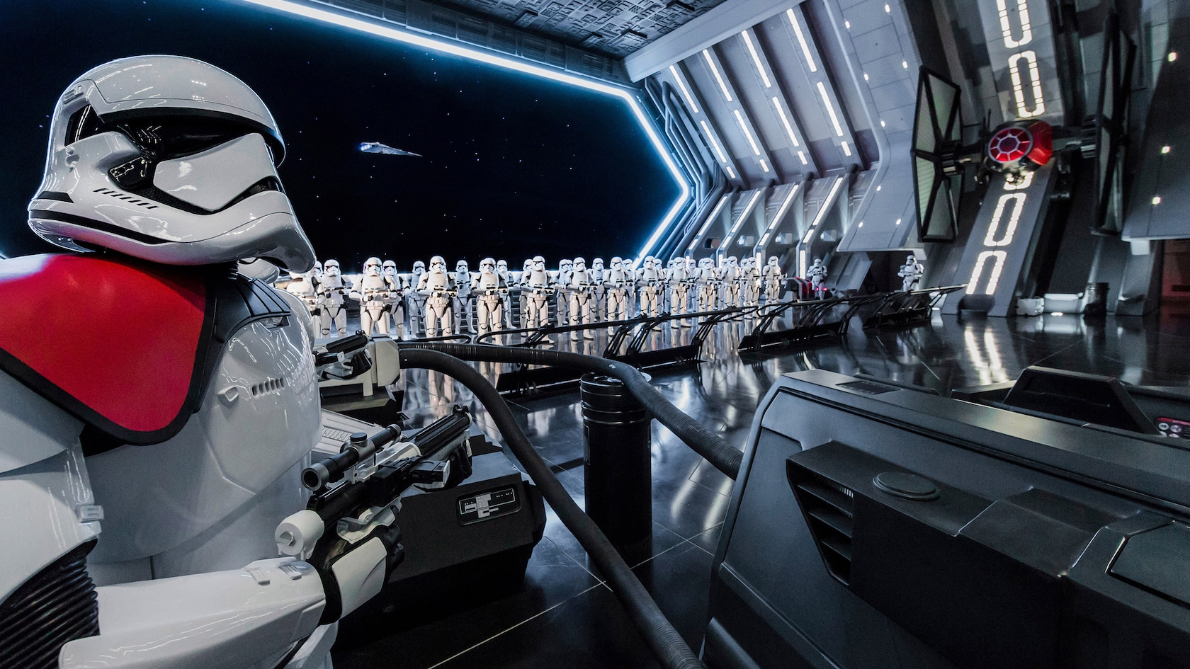 Rows of First Order stormtroopers and a TIE fighter line the inside of a Star Destroyer docking bay