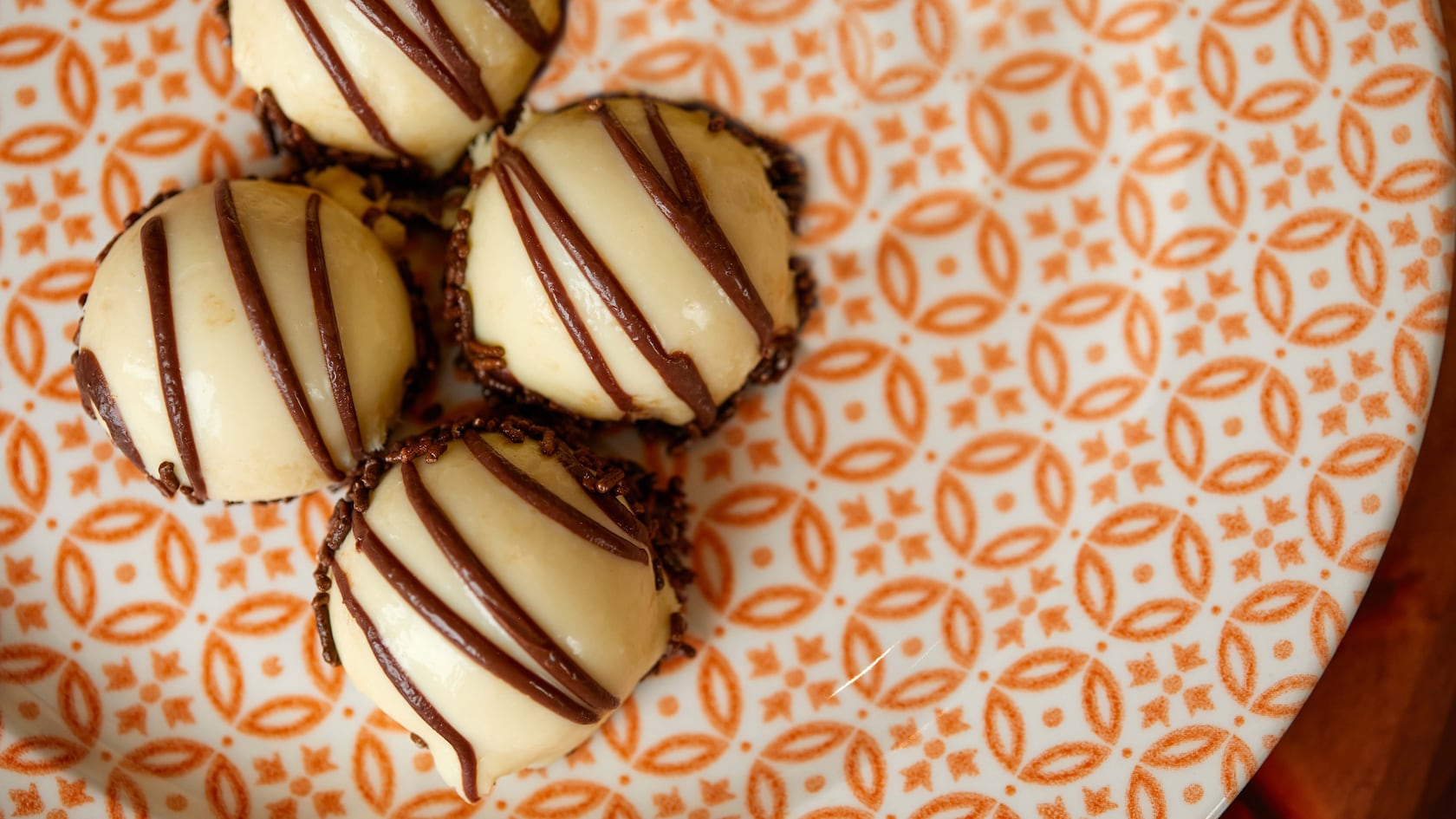 Four dome shaped pastries are displayed on a plate