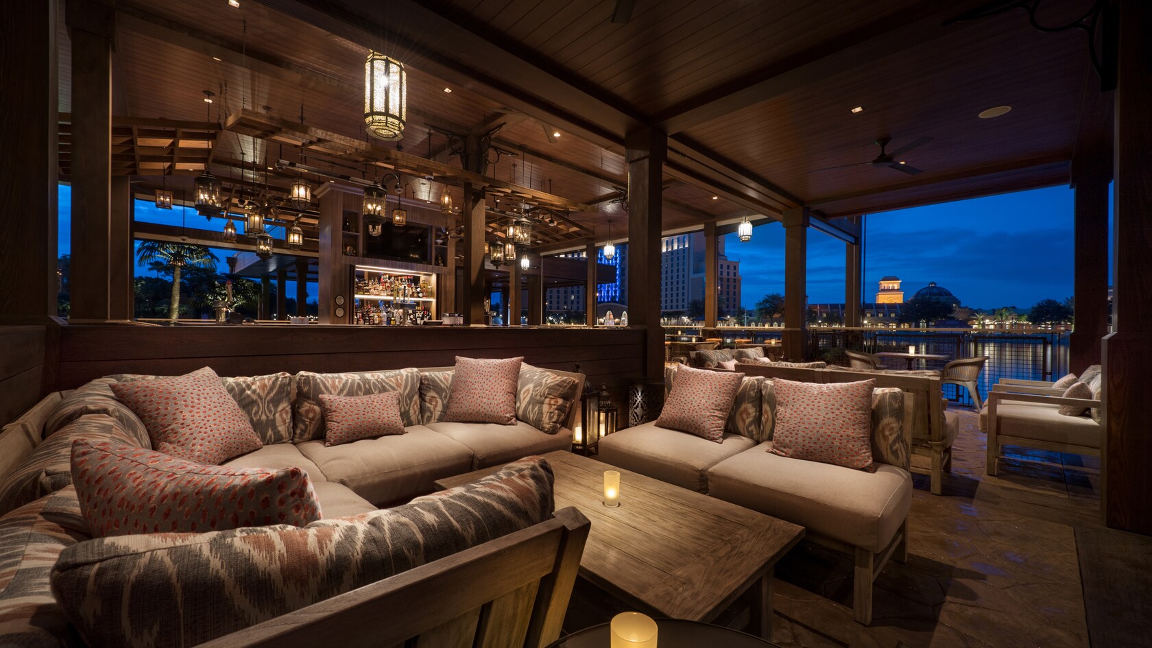 Cómodos sofás con almohadas rodean una mesa con una vela iluminada 