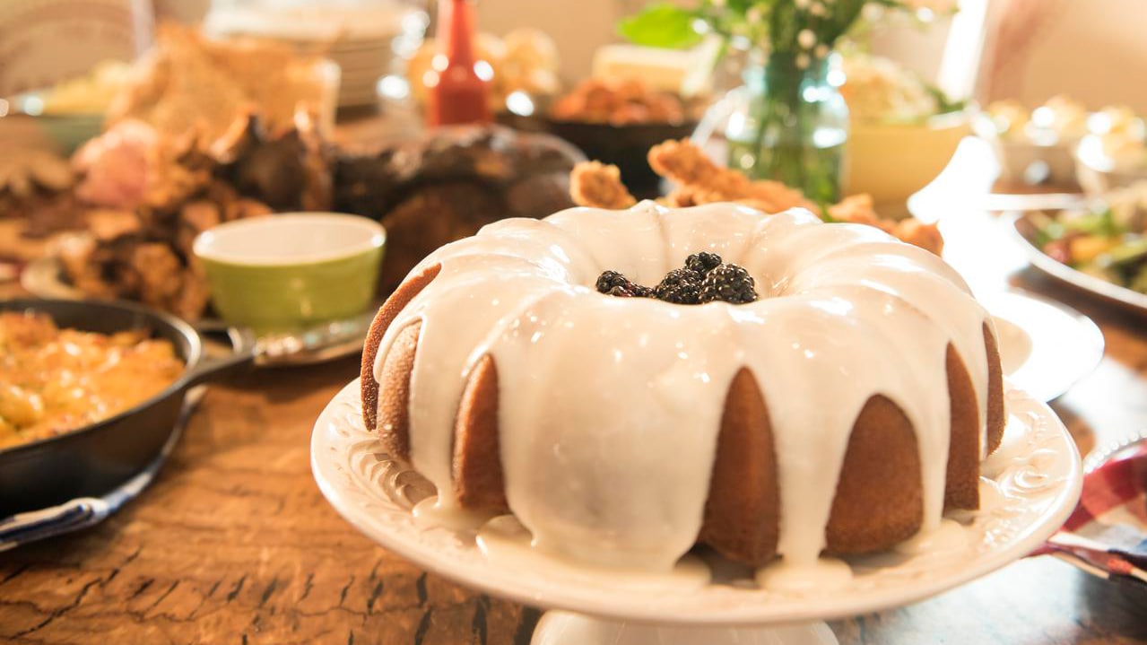 Iced Moonshine Cake on a pedestal among assorted dishes