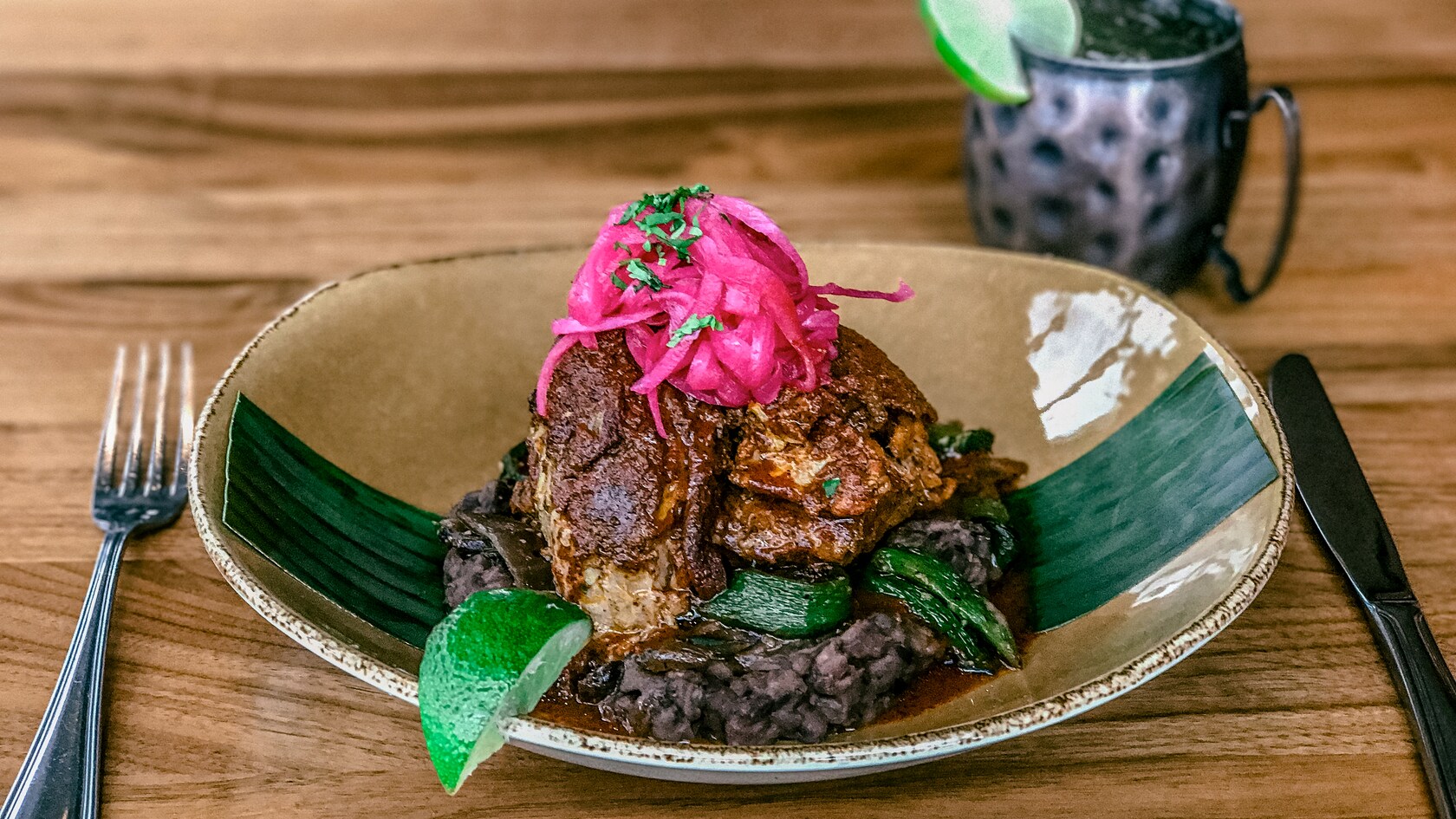 Slow roasted pork served with black beans and topped with pickled onions
