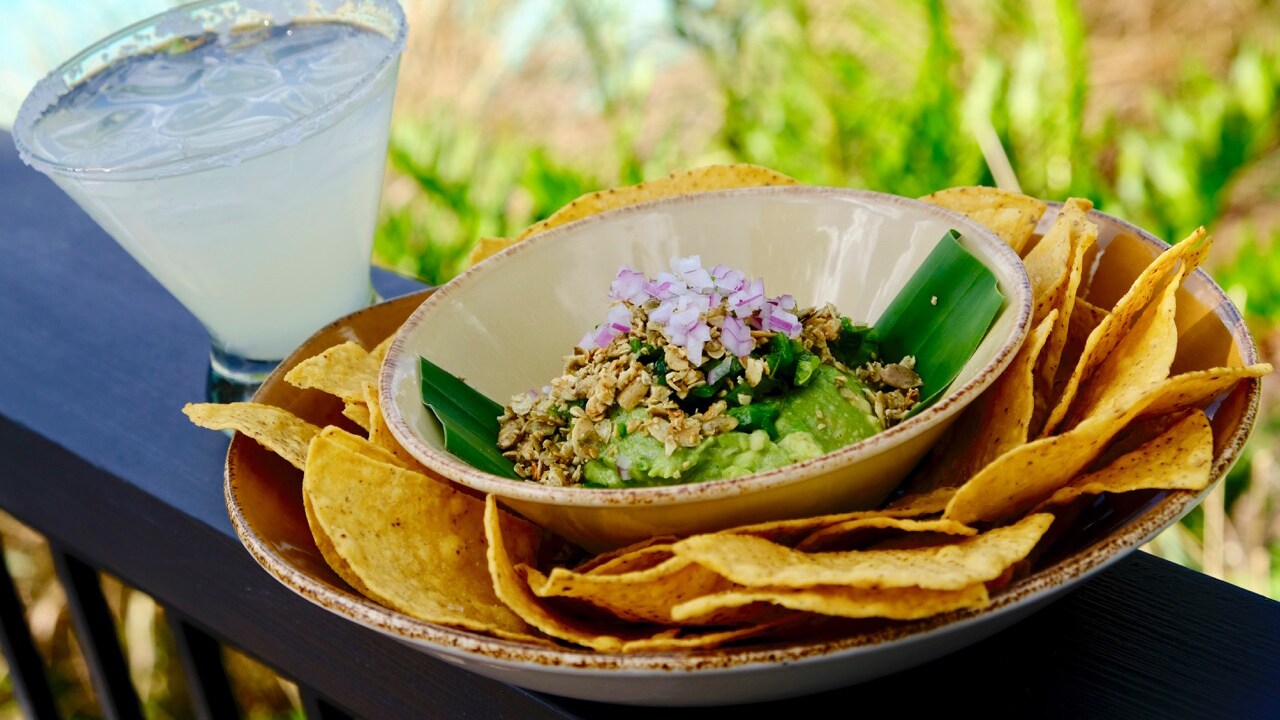 Corn chips served with guacamole topped with toasted pumpkin seeds and diced onion 