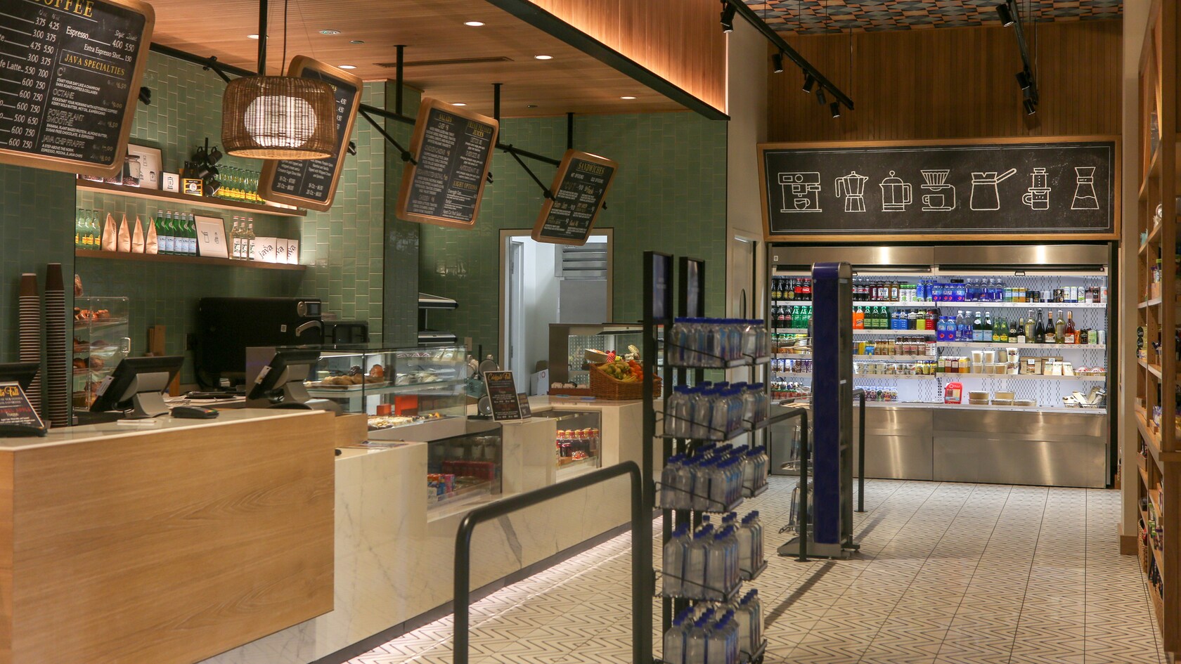 Un café contemporain avec un coin réservé à la commande au comptoir et un présentoir réfrigéré contenant des boissons et des collations à emporter
