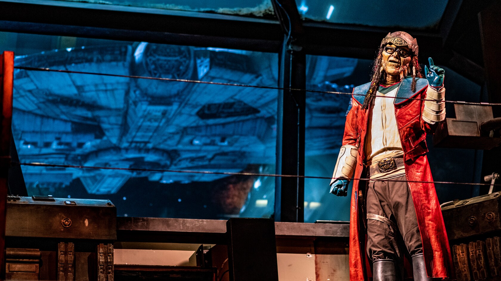 Hondo Ohnaka gives instructions while the Millennium Falcon appears on a large screen behind him.