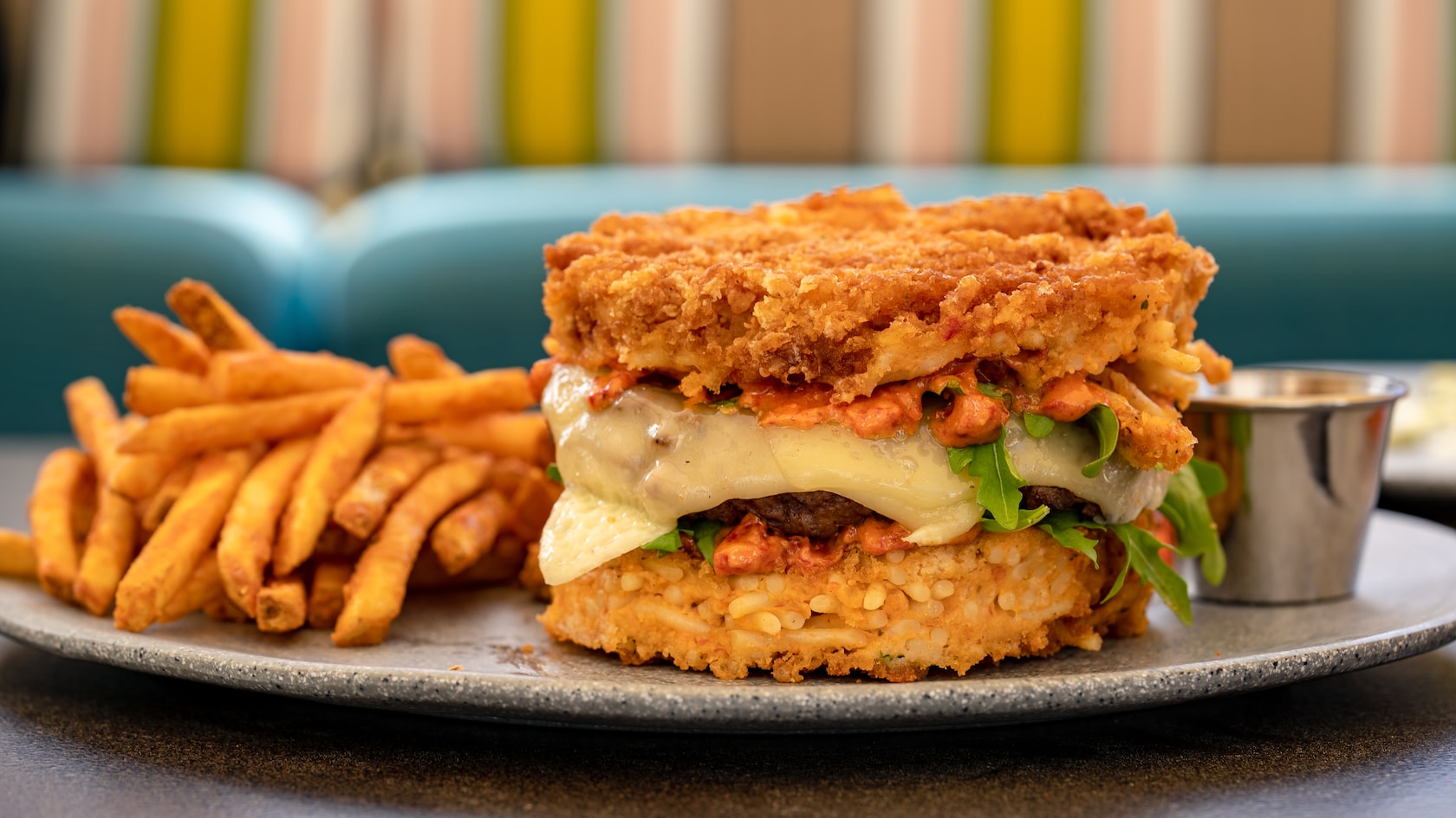 A cheeseburger that has battered spaghetti as its buns, served with french fries