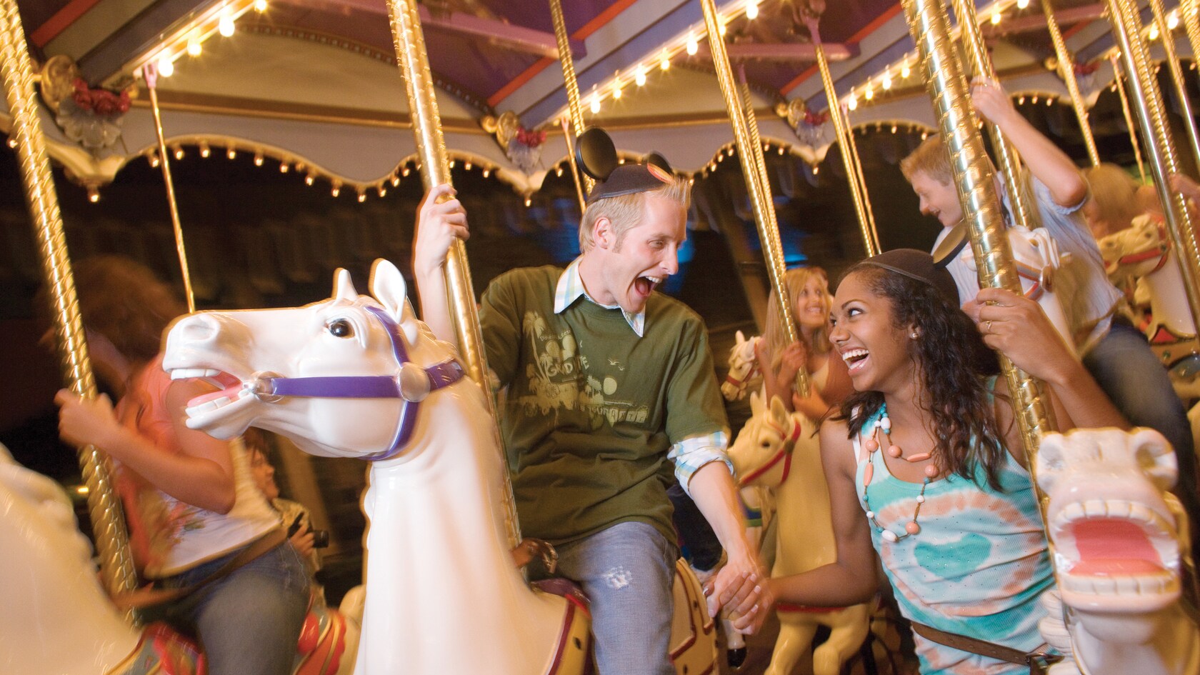A couple laughs together on a carousel