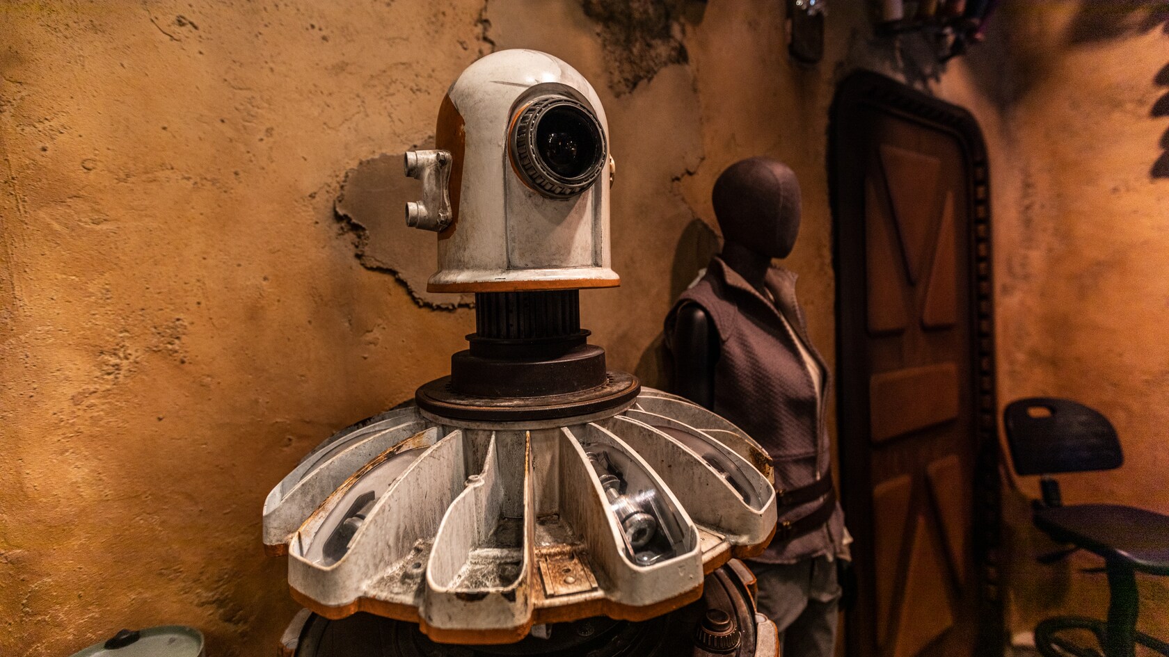 A programming droid stands beside a mannequin inside Black Spire Outfitters.