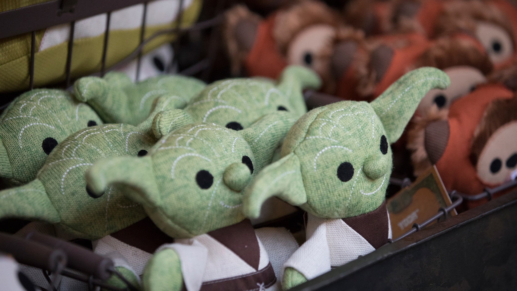 Plush Yoda and Ewok toys on a shelf.